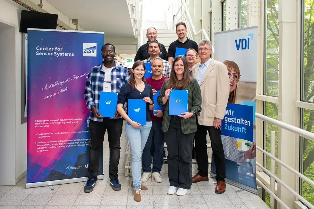 Winners of the 2026 ZESS PhD Research Forum awards pose with blue VDI folders.