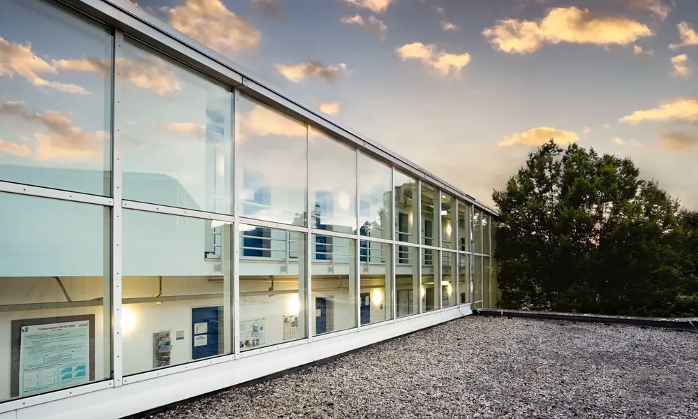 Glass-fronted exterior of the Center for Sensor Systems at the University of Siegen at dusk.